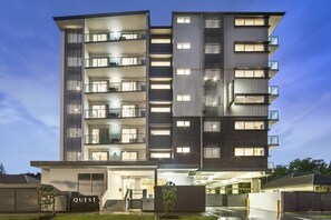 A multi-story hotel with balconies, a well-lit entrance, and a sign reading "QUEST". - Quest Chermside on Playfield (Chermside)