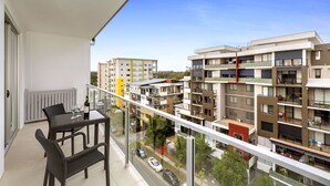 A balcony with a table and chairs, overlooking a residential area with modern apartment buildings. - Quest Chermside on Playfield (Chermside)