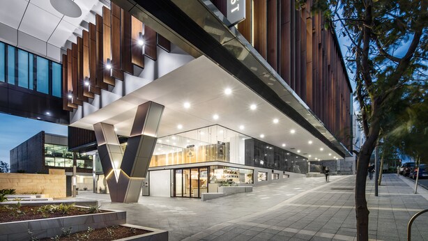 A modern hotel with a prominent 'QUEST' sign, large windows, and a well-lit entrance area. - Quest St Leonards (St. Leonards)