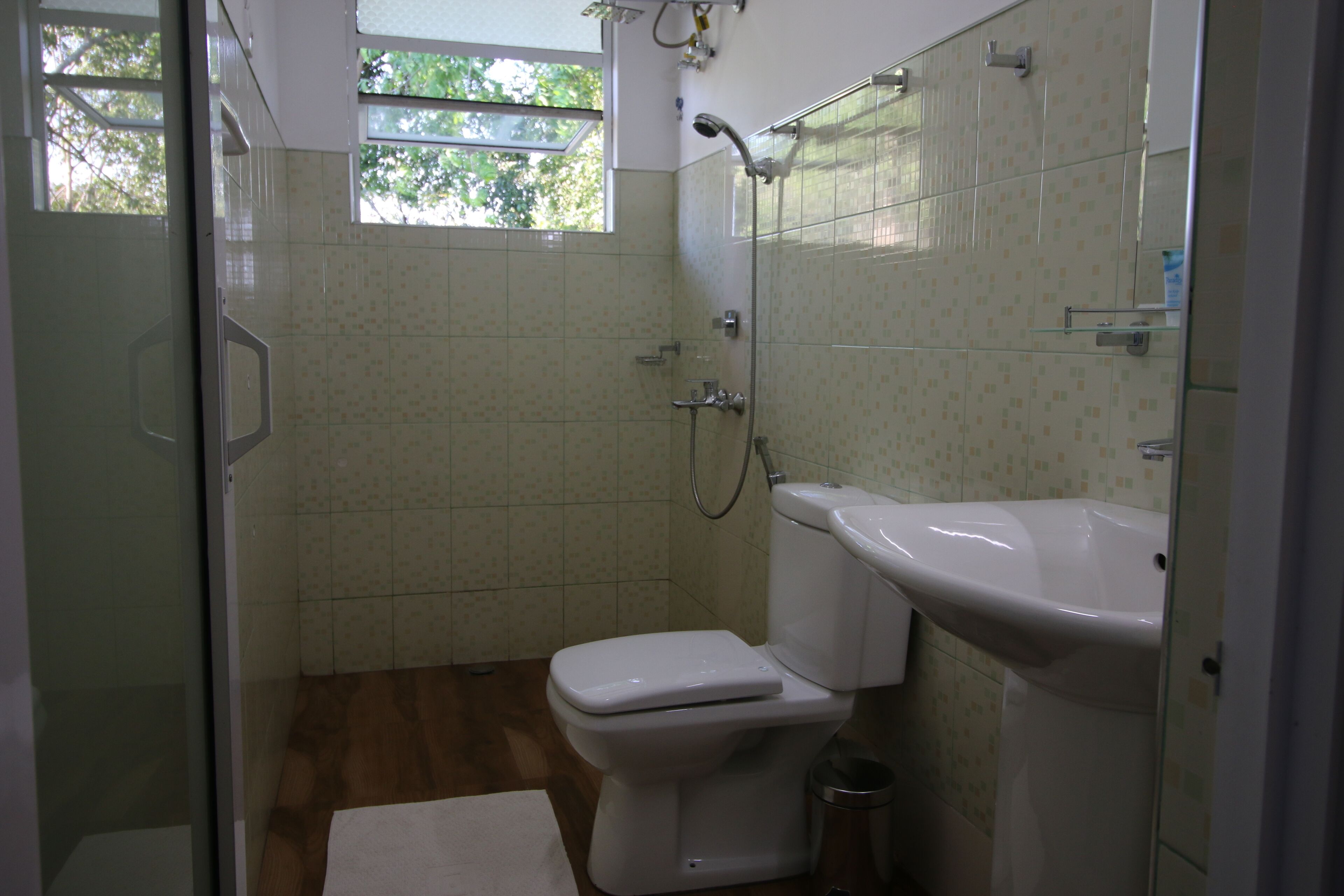 Un baño pequeño con inodoro, lavamanos y ducha.