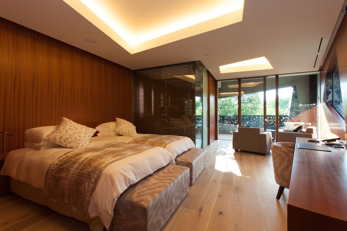 Un dormitorio moderno con una cama grande, un escritorio y vistas al exterior.