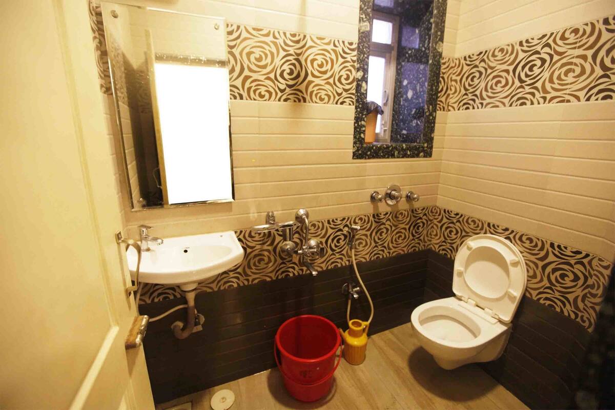A bathroom with a sink, toilet, and a mirror.
