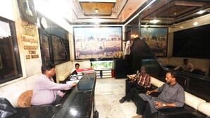 A hotel lobby with a reception desk, seating area, and large windows with city views. - Hotel Al Moazin (Mumbai)