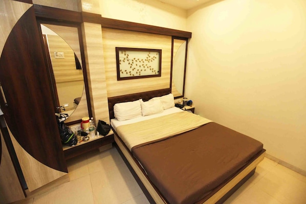 A bedroom with a bed, bedside tables, a mirror, and a wall-mounted artwork.