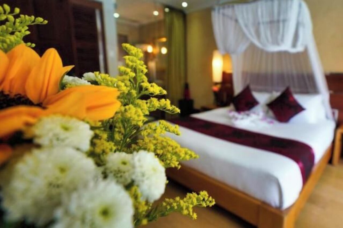 Una habitación de hotel con una cama, una mesita de noche y un buró.