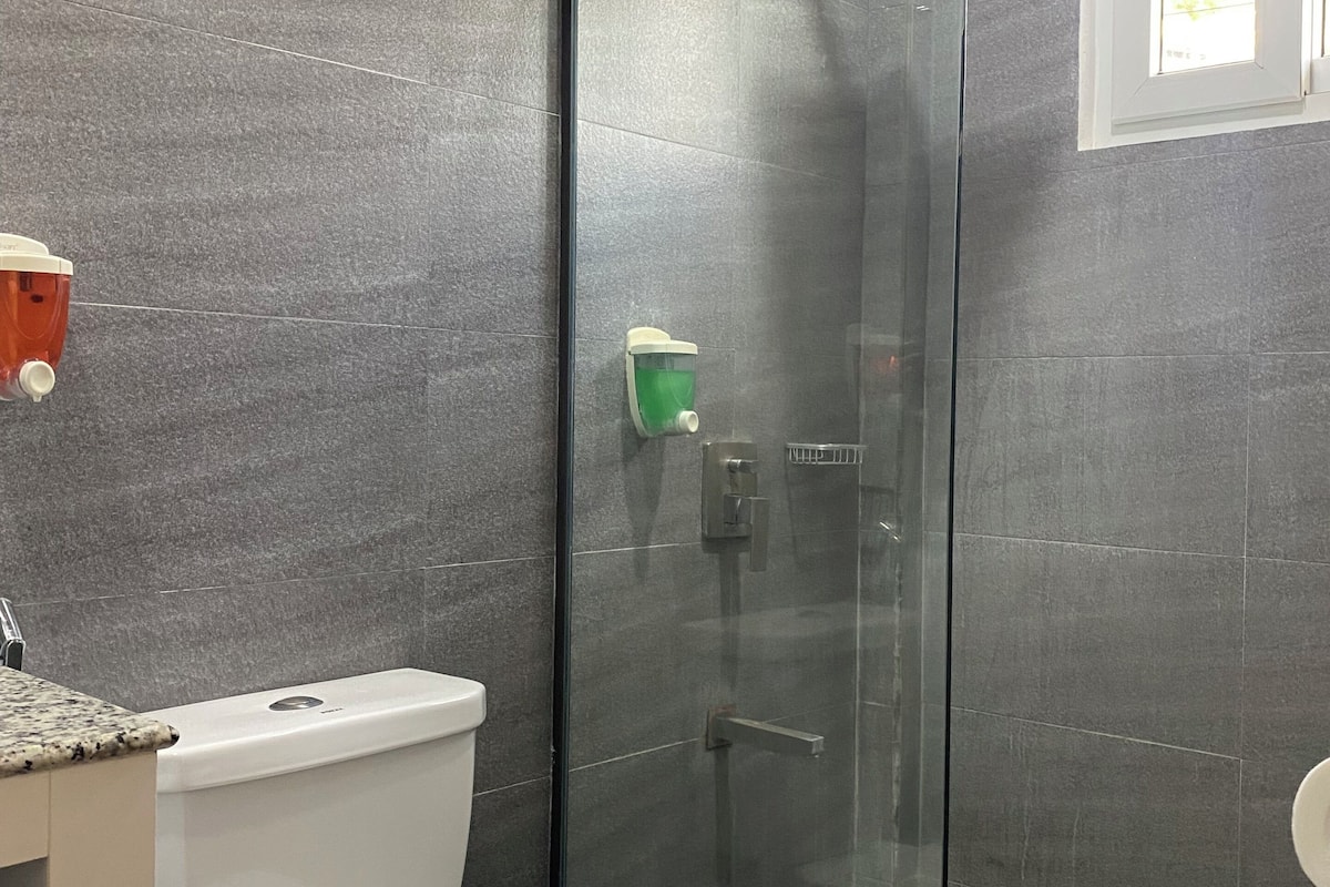 standard room | bathroom | shower, rainfall showerhead, hair dryer, slippers