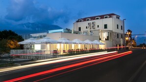 A hotel with outdoor seating and a mountain backdrop.