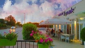 A restaurant named 'Konavle' with outdoor seating and a view of the street.
