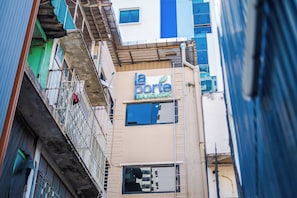 Un estrecho callejón entre edificios, con un letrero visible que dice 'la porte bangkok'.