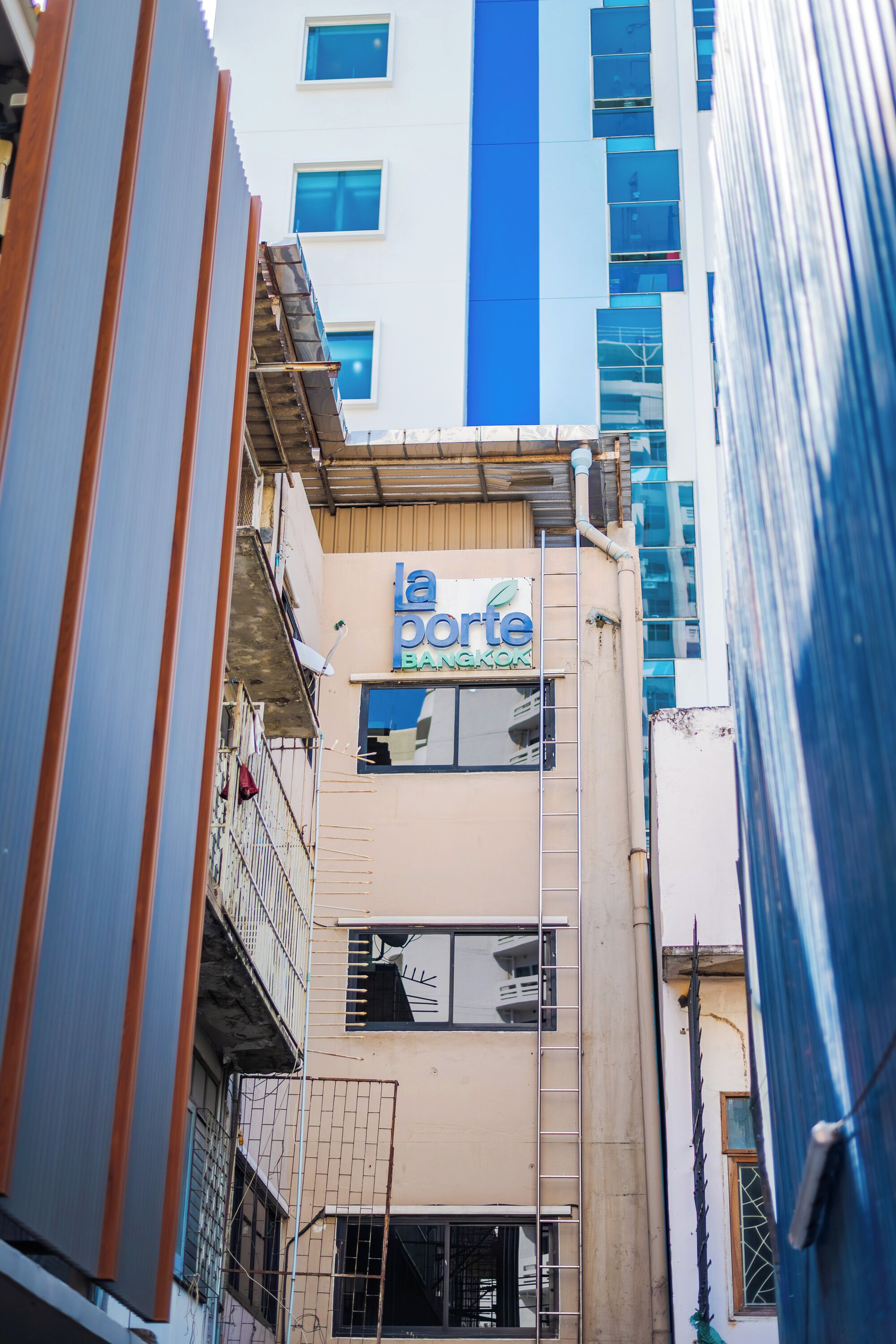 A multi-story building with a sign for 'la porte Bangkok' on the facade.