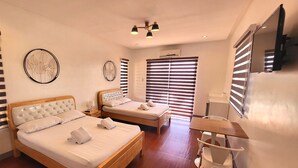 A modern hotel room with two beds, a desk, and a TV. - Bakasyunan Resort Tanay (Tanay)