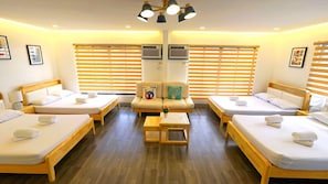 A hotel room with four single beds, a sofa, and a small table. - Bakasyunan Resort Tanay (Tanay)