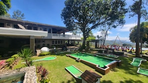 A pool area with multiple green pools, a large white golf ball, and a building with a balcony. - Bakasyunan Resort Tanay (Tanay)