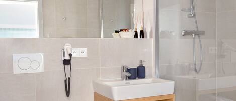 A modern bathroom with a toilet, sink, and shower.