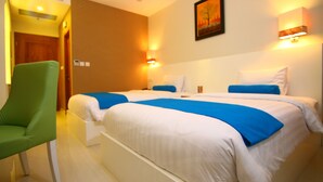 A hotel room with a large bed, a green chair, and a painting on the wall. - The Falatehan Hotel (Jakarta)