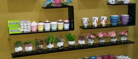 Una exhibición de diversos productos en estantes, incluyendo artículos de tocador, elementos decorativos y pequeños recipientes.