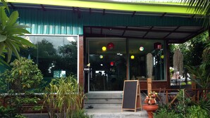 A building entrance with a glass door, steps leading up to it, and a welcome sign. - Samui Poshtel (Koh Samui)