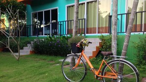 A bicycle parked in front of a building with a green and orange facade. - Samui Poshtel (Koh Samui)