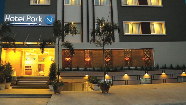 A multi-story hotel with a modern facade, illuminated windows, and a sign reading "Hotel Park". - Hotel Park N (Penumuluru)