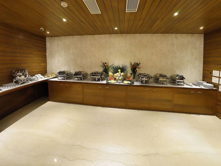 A buffet setup with various food stations and a beverage dispenser.