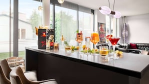 Un bar moderne doté d’un long comptoir, proposant une variété de boissons et offrant une vue sur l’extérieur.