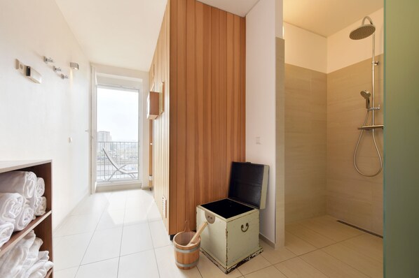 A modern bathroom with a shower, a wooden cabinet, and a view of the city. - eeeden apartments Graz (Graz)