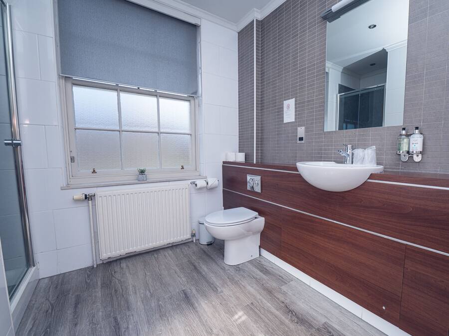 A modern bathroom with a toilet, sink, and window.
