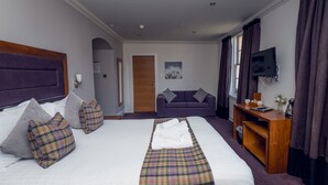 A hotel room with a large bed, a sofa, a TV, and a desk. - Fletcher's Restaurant Bar & Rooms (Stirling)