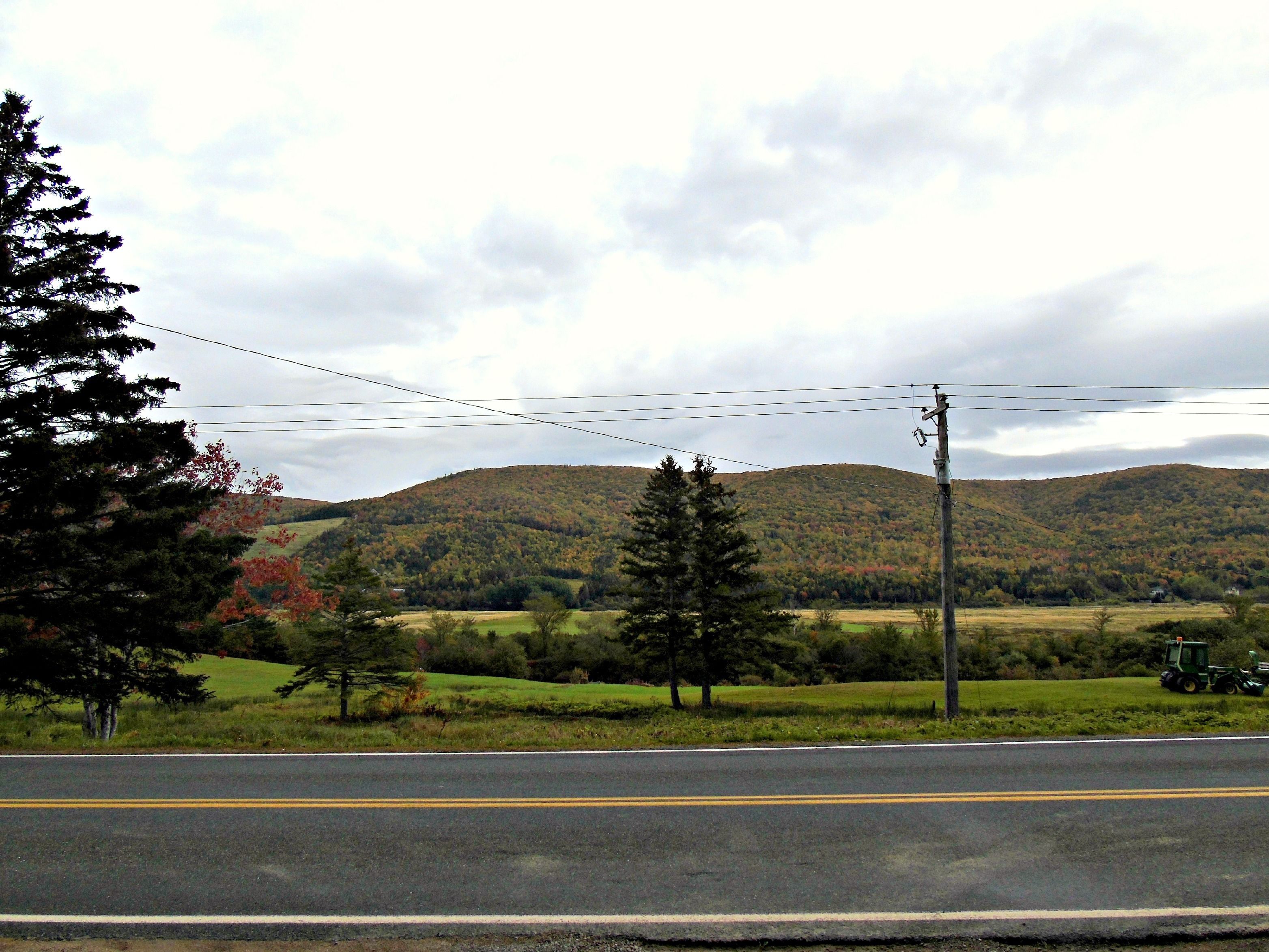 A rural road with a mountain in the background.