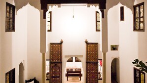 A traditional interior with a tiled courtyard, wooden furniture, and decorative lanterns. - Riad Porte Royale (Marrakech)