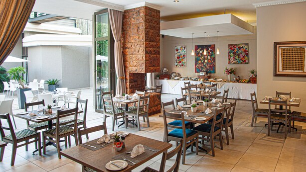 A restaurant with multiple dining areas, a brick fireplace, and artwork on the walls.