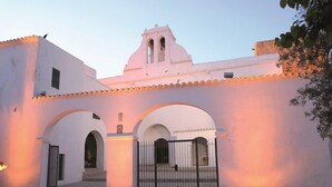 Un edificio blanco con arcos y un campanario, que sugiere un lugar histórico o cultural.