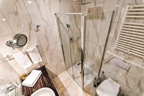 Une salle de bain moderne avec une douche à parois de verre, un meuble-lavabo avec un miroir et des toilettes.