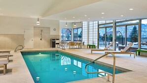 An indoor swimming pool with a view of snowy mountains, a sunlit room with a table and chairs, and a large window. - Element by Marriott Basalt - Aspen (Basalt)