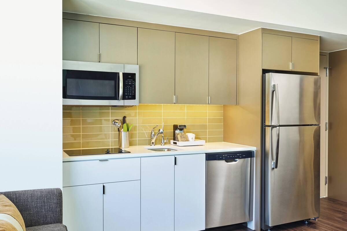 A modern kitchen with stainless steel appliances, a dishwasher, and a microwave.