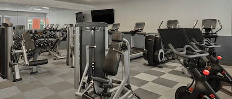 A gym with various exercise machines, including treadmills, ellipticals, and weight machines.