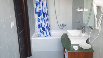 Un bagno moderno con una vasca, una doccia, un lavandino e un water.