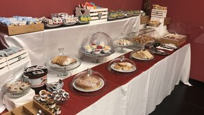 A buffet table with various food items and condiments. - Ascot Hotel (Caianello)