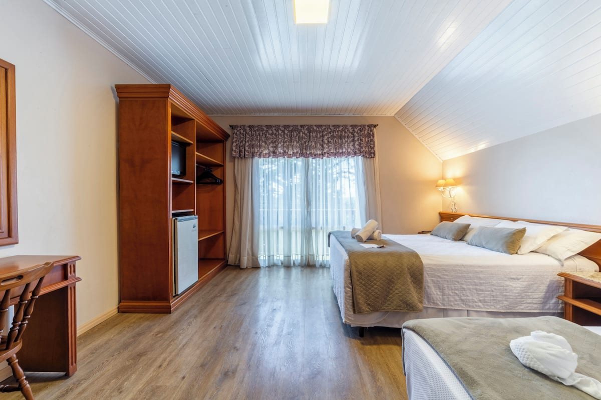 A bedroom with a bed, bedside table, and a wooden wardrobe.