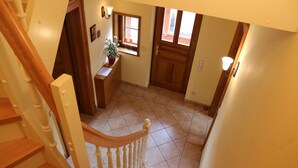 Una escalera que lleva a un rellano con una puerta de madera y una ventana.