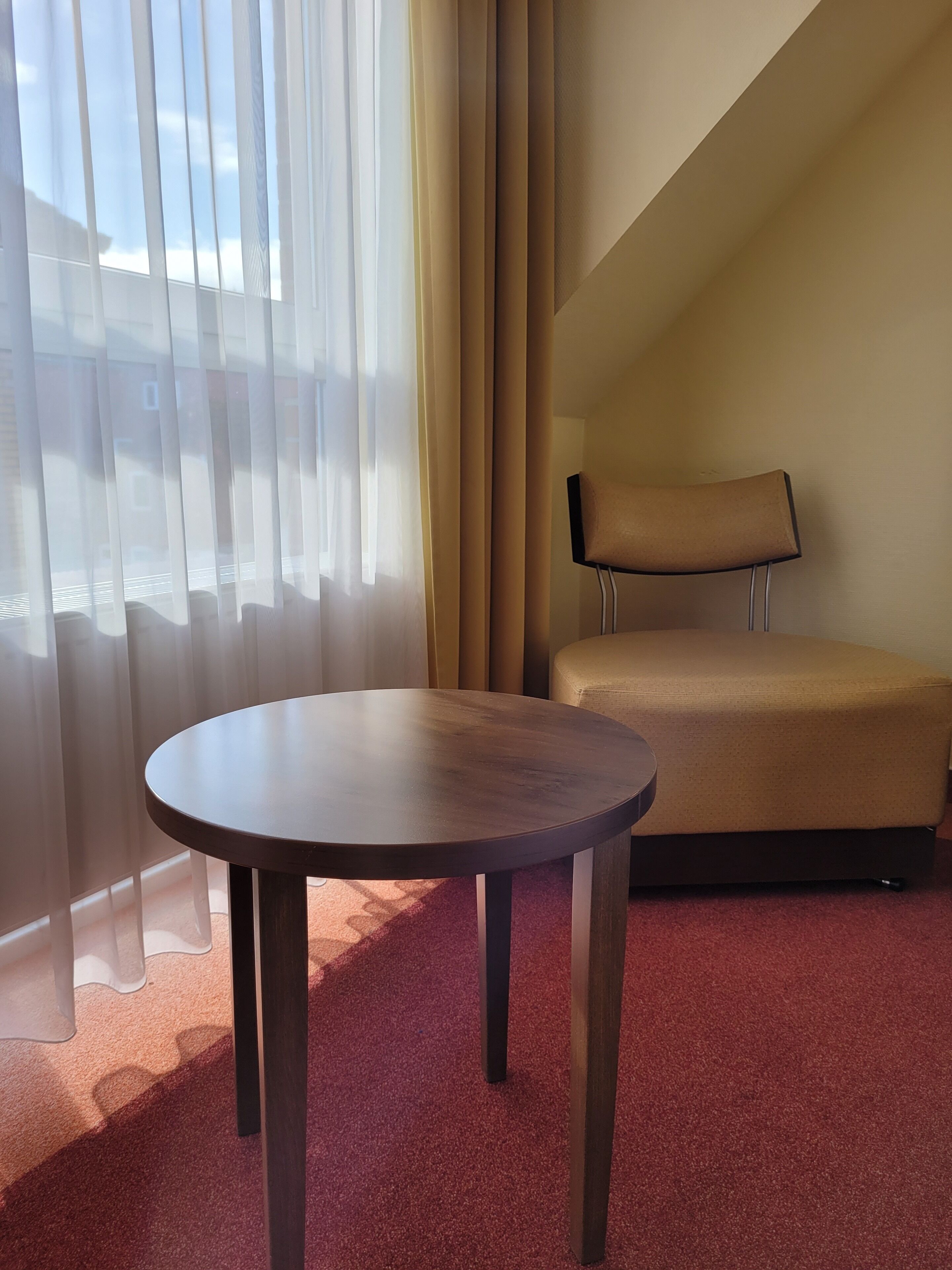 Une pièce avec une table ronde, un canapé et un téléviseur posé sur un meuble.