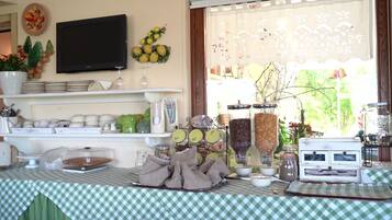 A breakfast buffet setup with various food items and utensils on display.