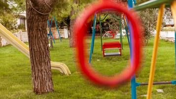A playground with a swing set and slides.