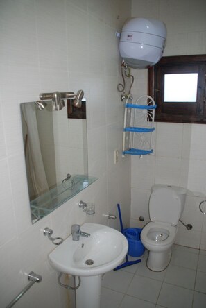 A bathroom with a toilet, sink, mirror, and a shower head. - Criss Haya Apartments (Sharm El Sheikh)