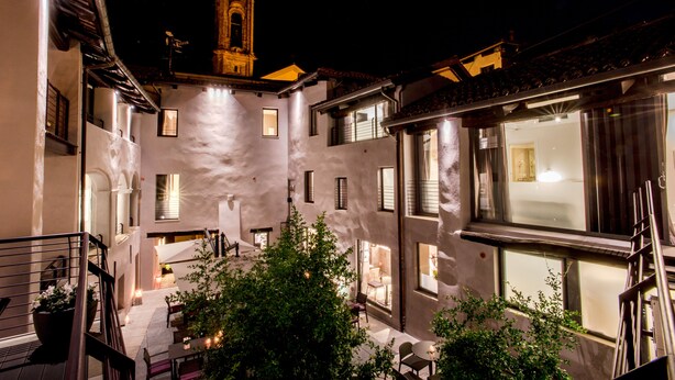 Un patio con una torre de campanas, varias ventanas y una escalera que conduce a un nivel superior.