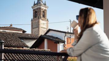 Una donna in piedi su un balcone con vista su un edificio storico e un campanile.