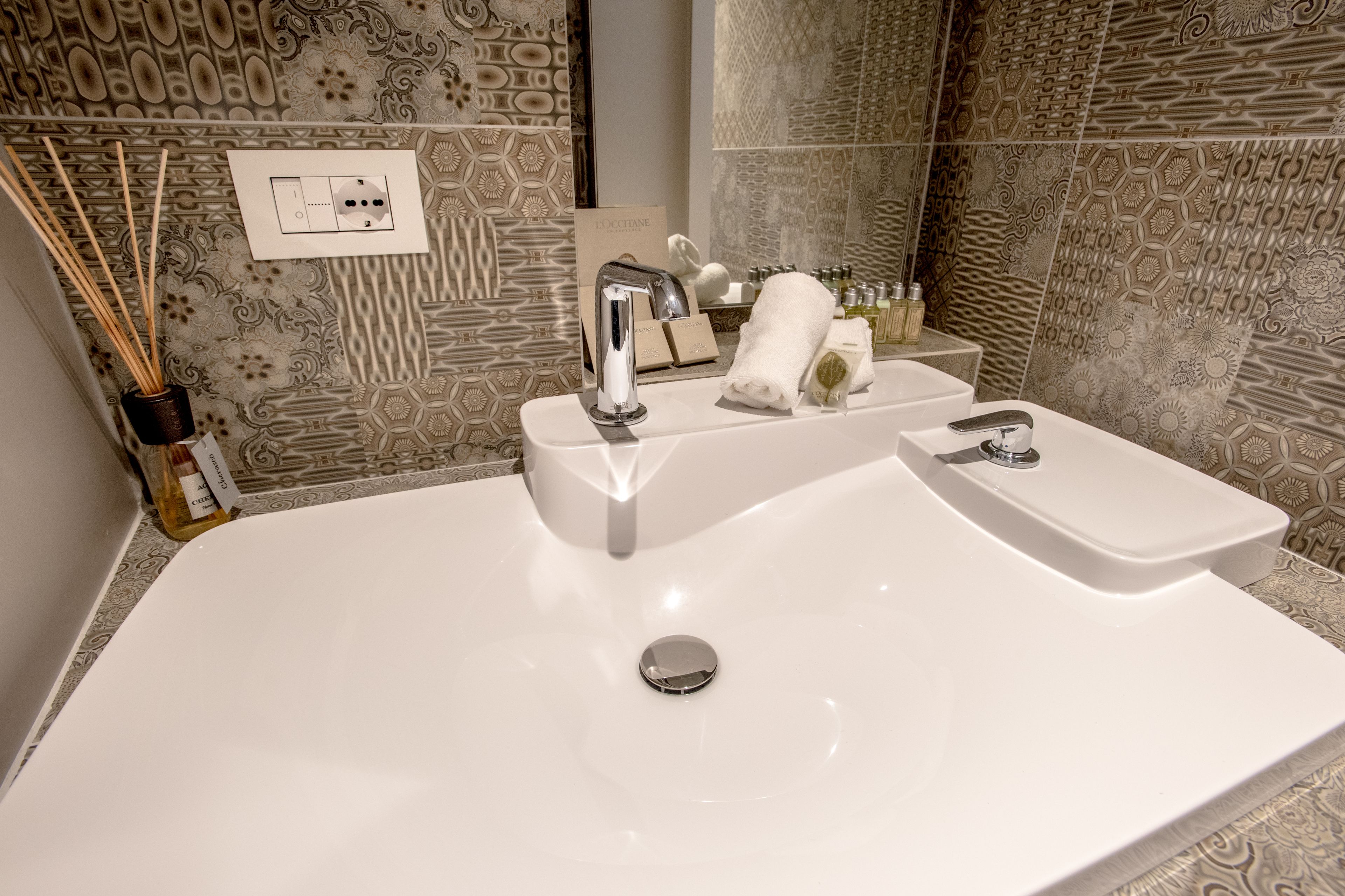 A bathroom with a double sink, a mirror, and a towel rack.