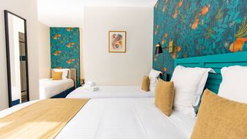 A hotel room with two beds, a large mirror, a wall with a fish pattern, and a framed picture.