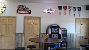 Eine Barbereich mit Holztüren, einer Jukebox und verschiedenen Bannern an der Wand.