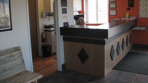 A kitchen with a wooden island, a bench, and a window with a view. - Iron Horse Inn (Whitewood)